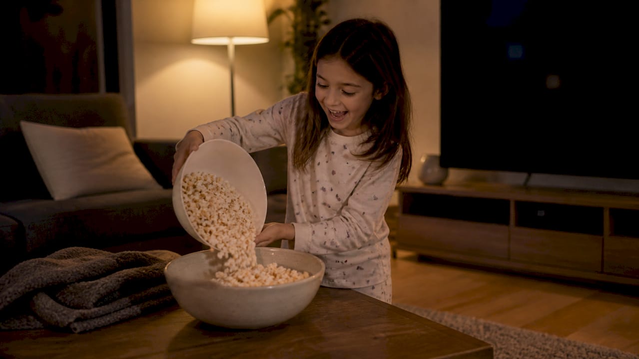 Bambino che versa i popcorn per la serata cinema in famiglia